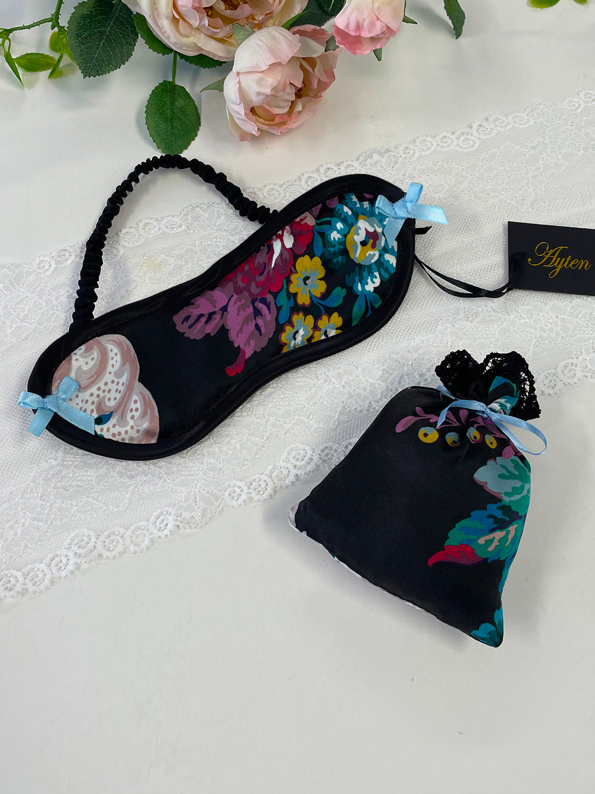 Luxurious Liberty London silk eye mask with floral pattern, black binding, and ribbon bows